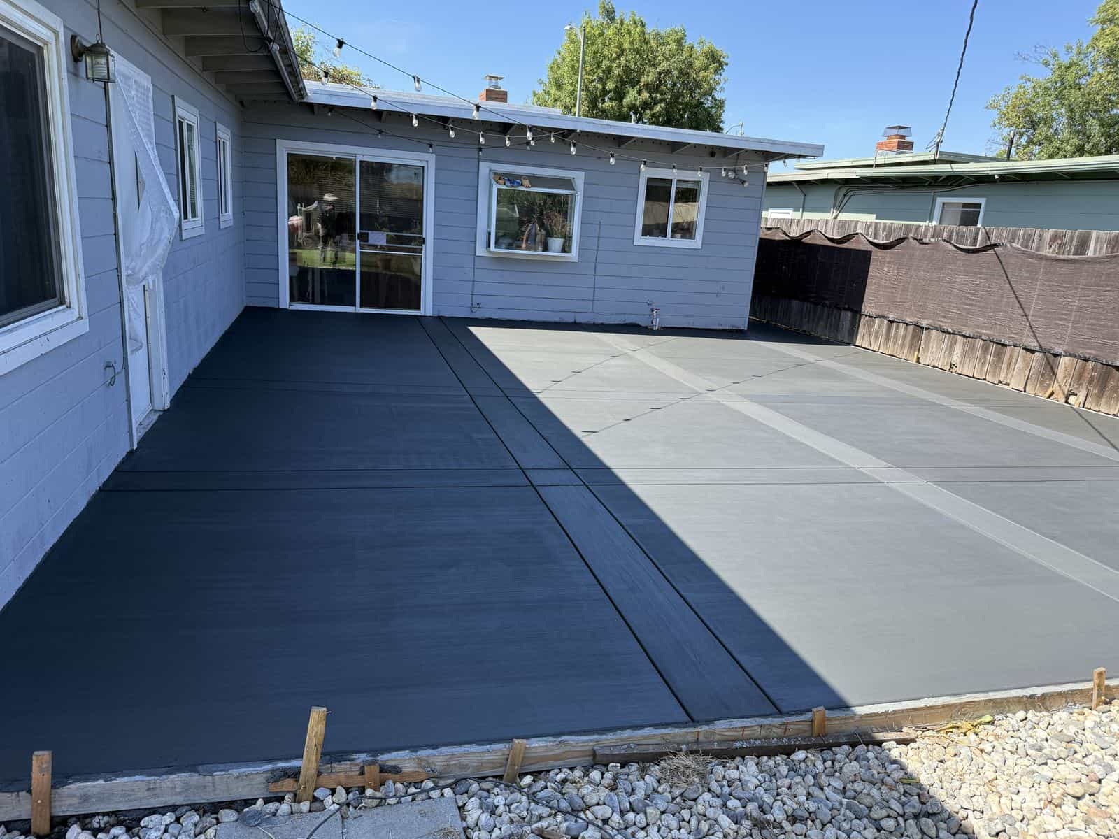 Freshly finished two-tone concrete patio behind a Bay Area home