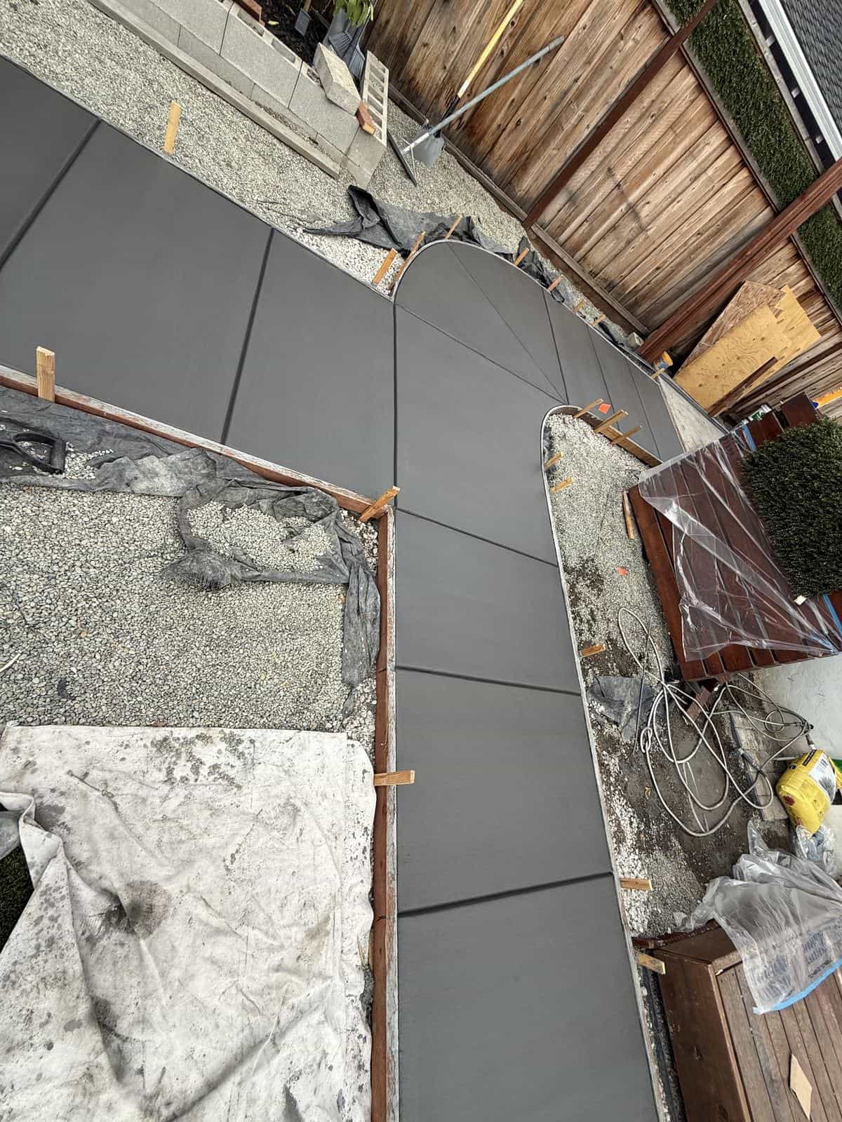 Curved concrete garden path with a clean edge running through planting beds