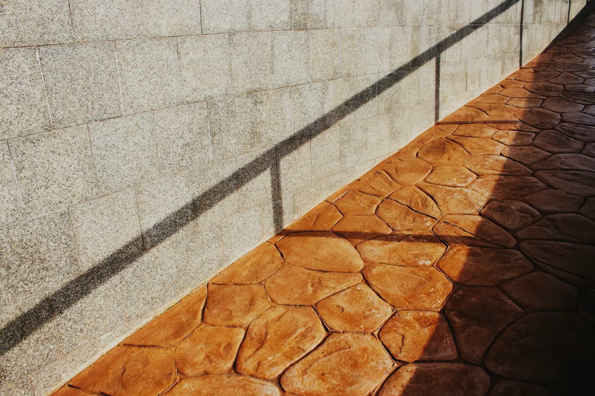 Sunlit stamped concrete walkway laid in a flagstone pattern