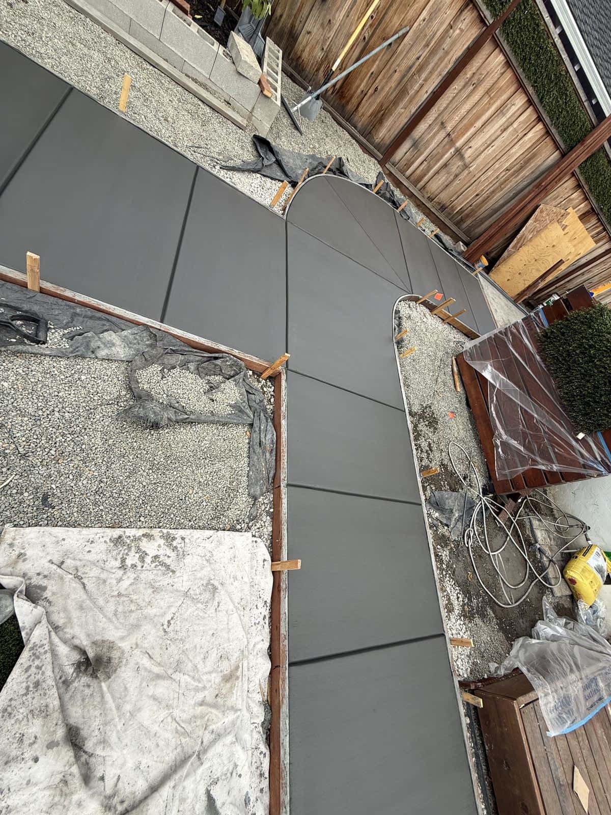 Curved concrete garden path with a clean edge running through planting beds