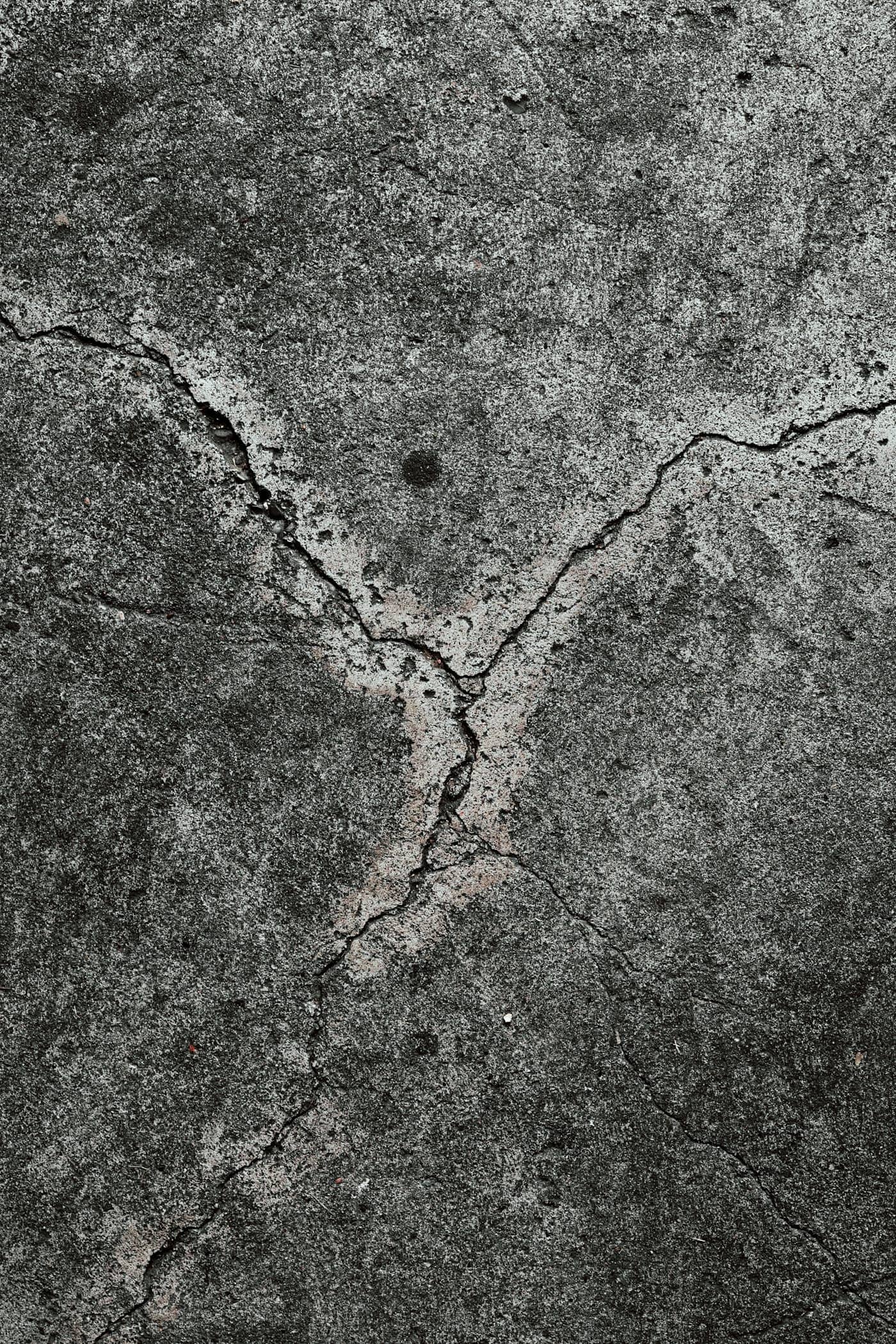 Weathered driveway slab with branching structural cracks