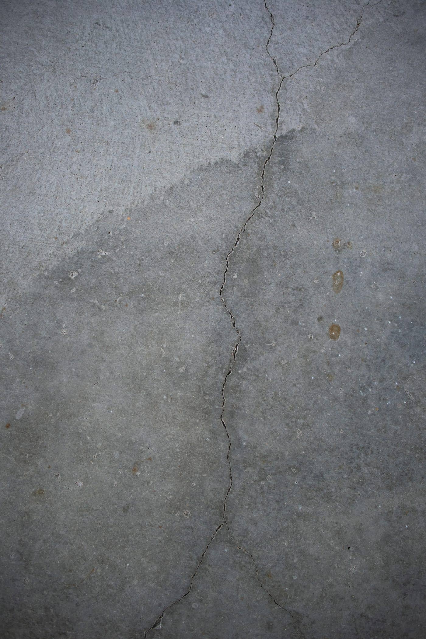 Cracked and vertically displaced sidewalk panel beside a fire hydrant