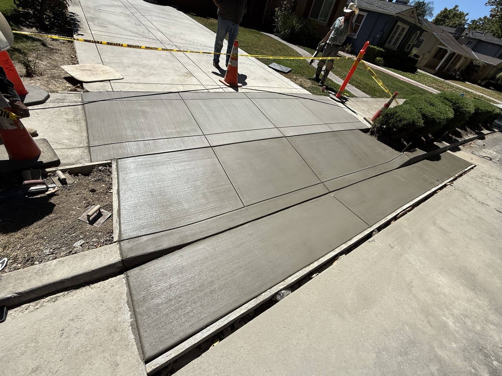 Close-up of a newly poured concrete driveway apron with clean control joints