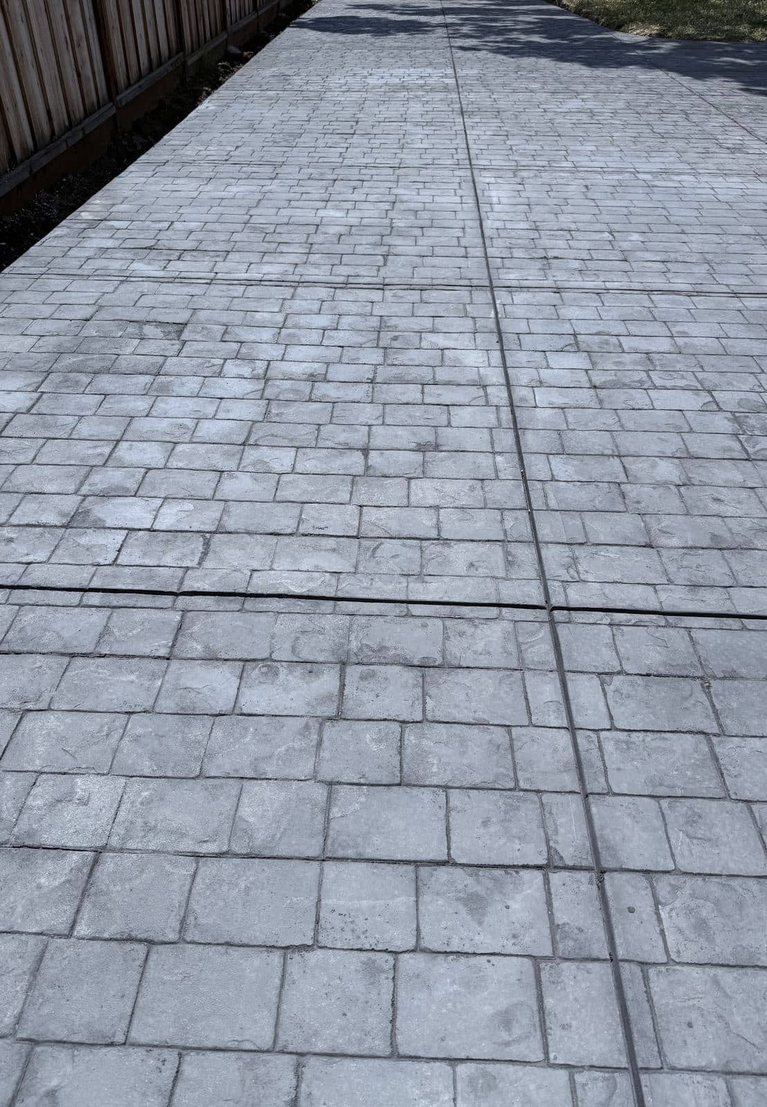Finished stamped concrete driveway in a gray ashlar stone pattern