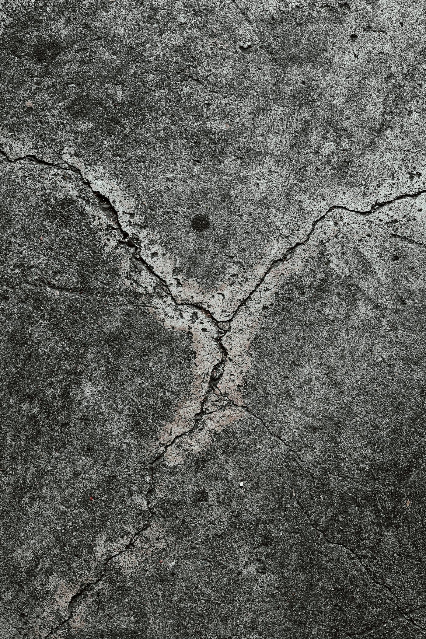 Weathered driveway slab with branching cracks and surface spalling