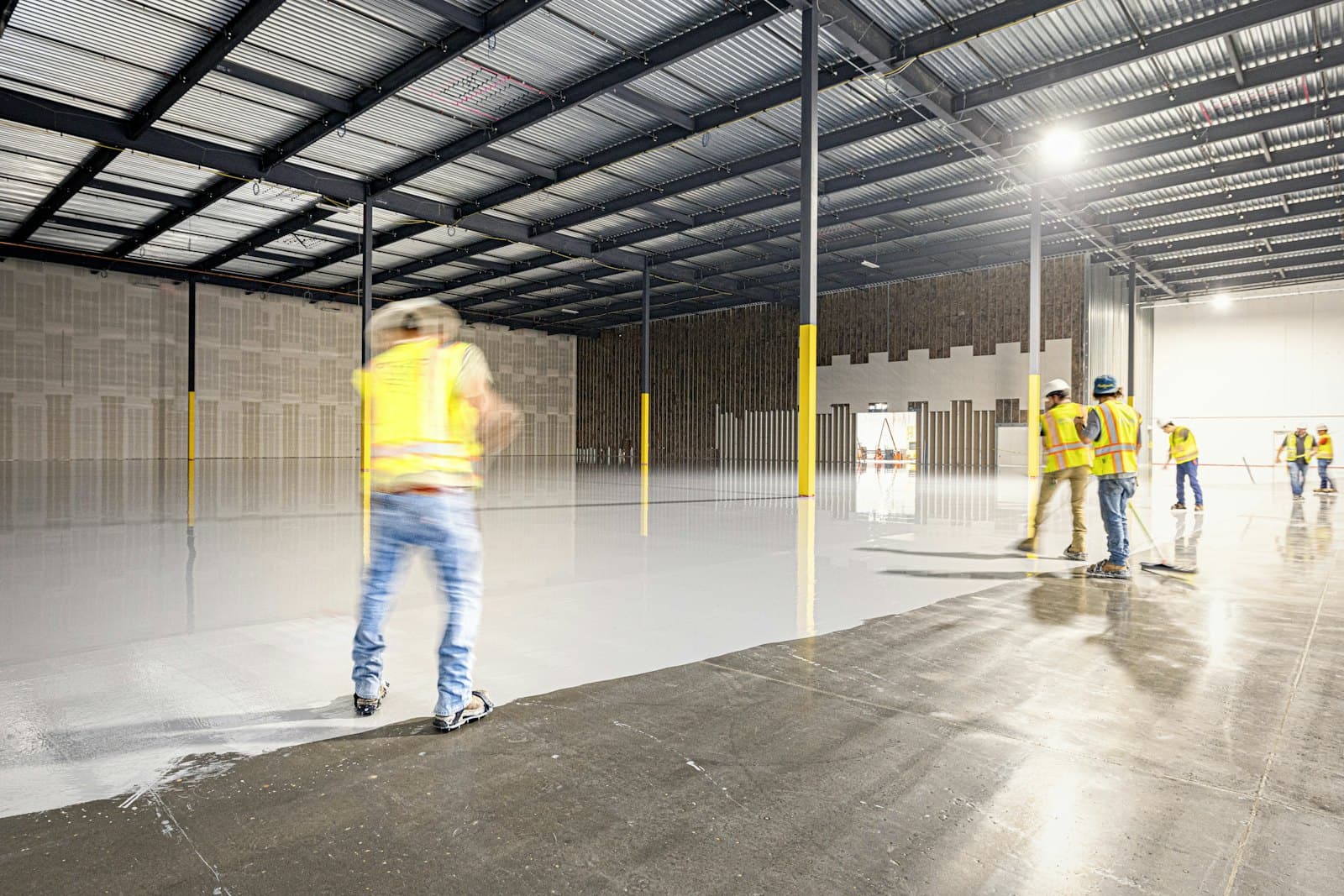 Crew inspecting a large warehouse with a smooth, level polished concrete floor