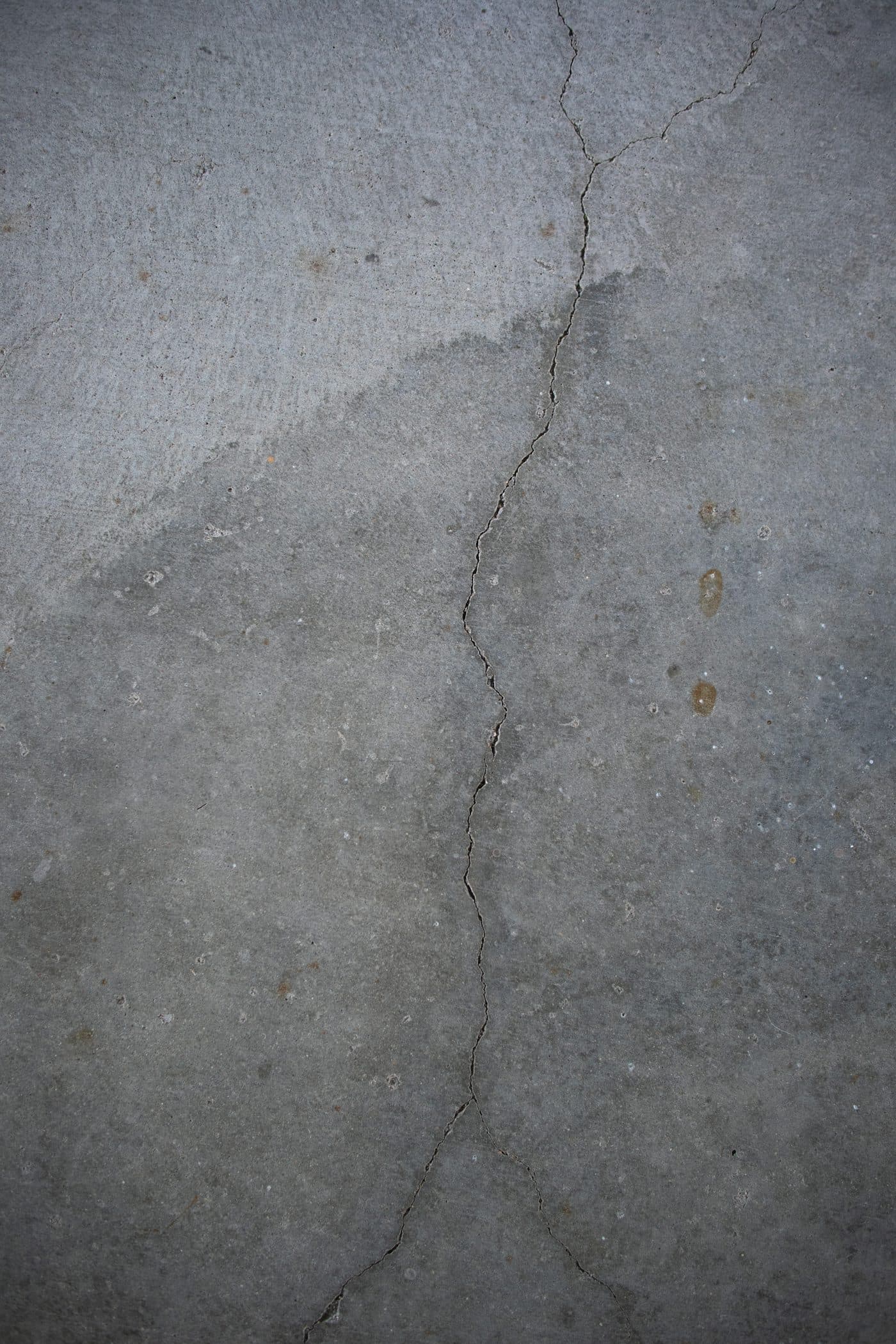 Cracked and vertically displaced sidewalk panel beside a fire hydrant