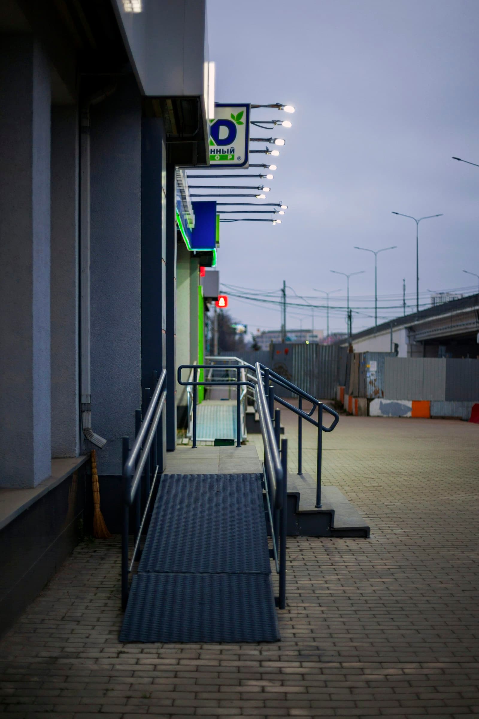 Accessible concrete entrance ramp with handrails alongside steps