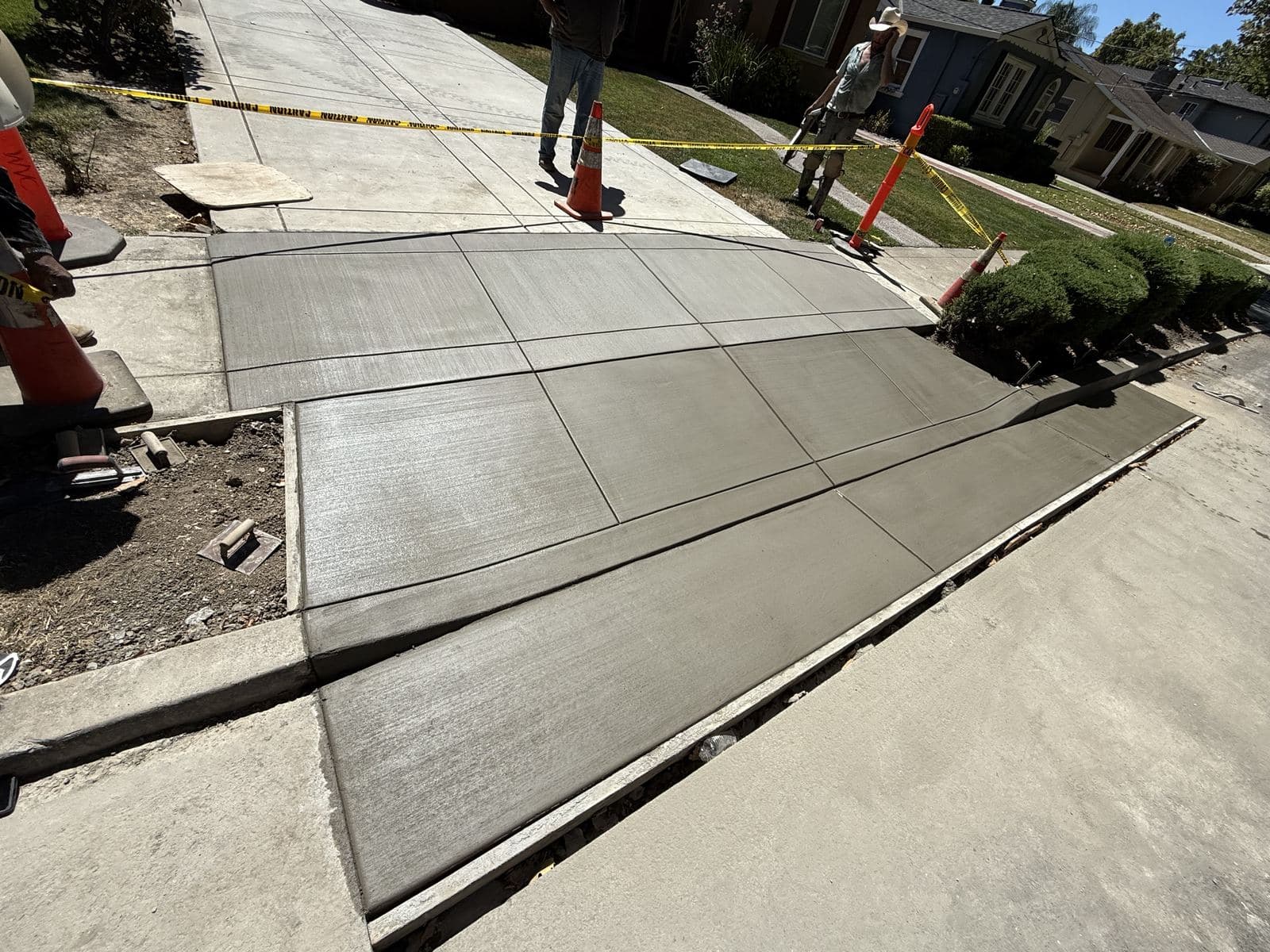 Close-up of a newly poured concrete driveway apron with clean control joints