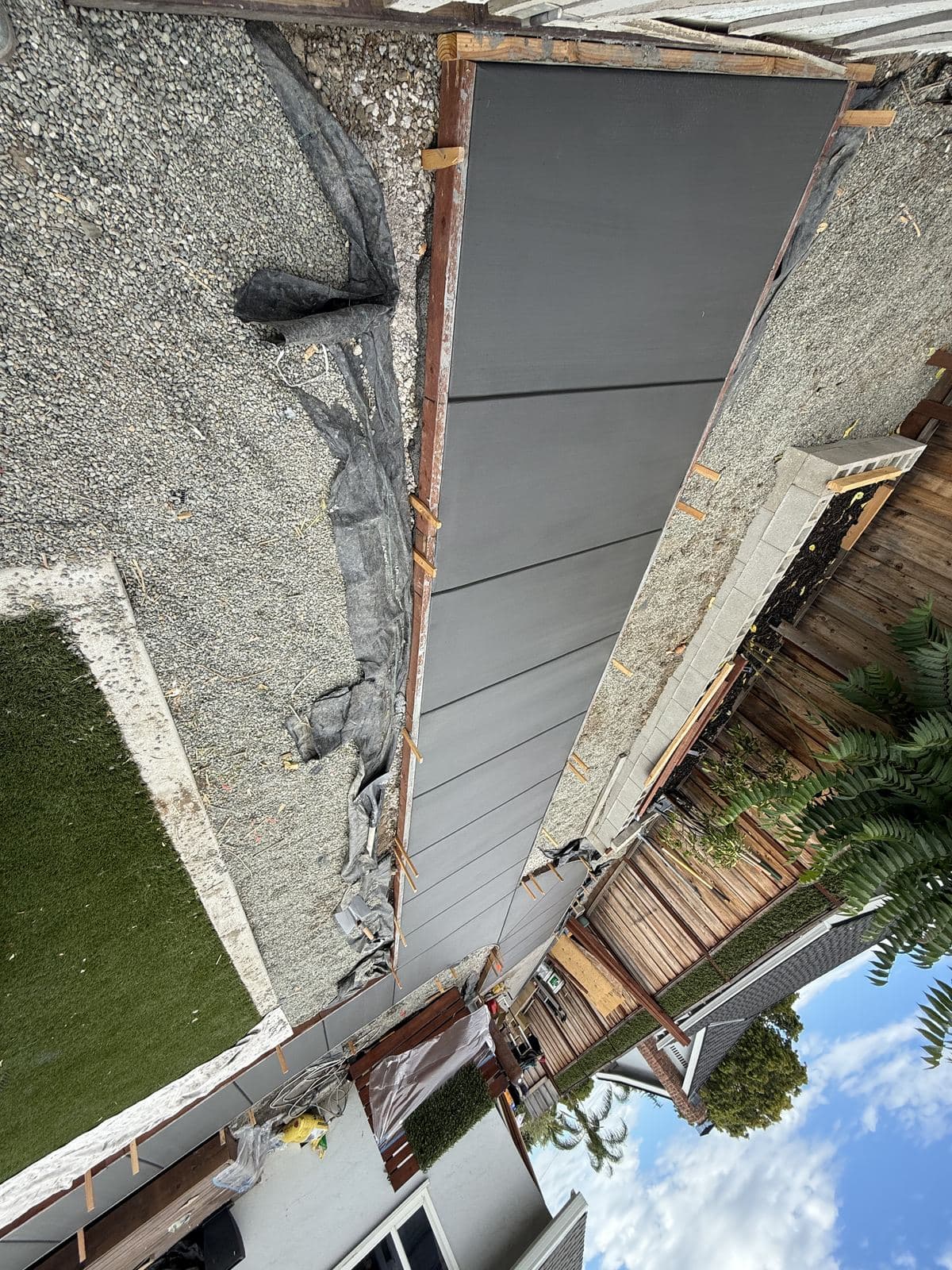 Finished concrete walkway seen from above running alongside a house