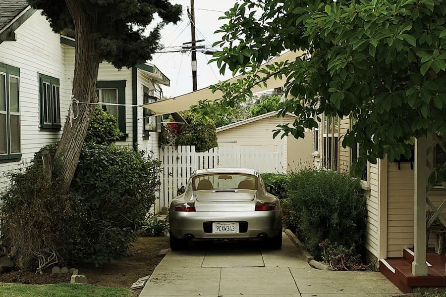 Car parked on a long residential concrete driveway