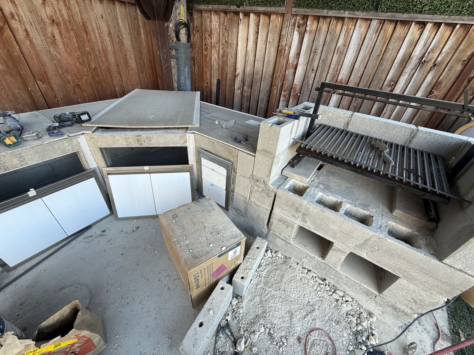 Outdoor kitchen island under construction with a built-in grill installed