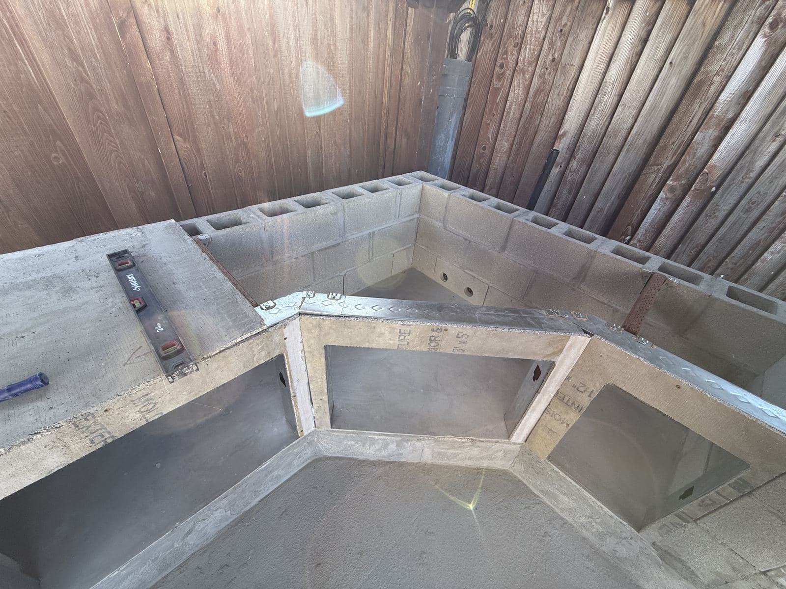 Cinder block outdoor kitchen frame under construction in a backyard