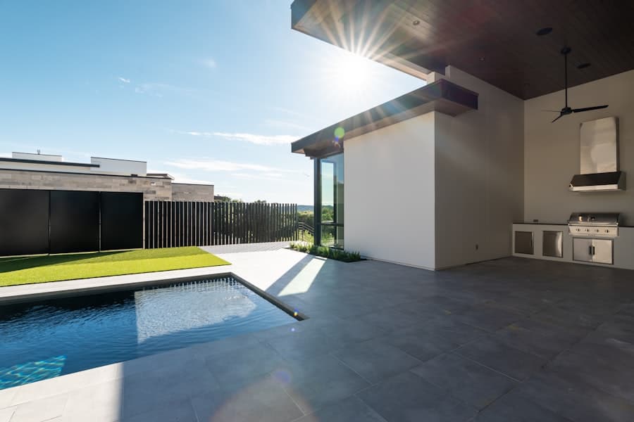 Modern concrete patio with swimming pool and outdoor kitchen area