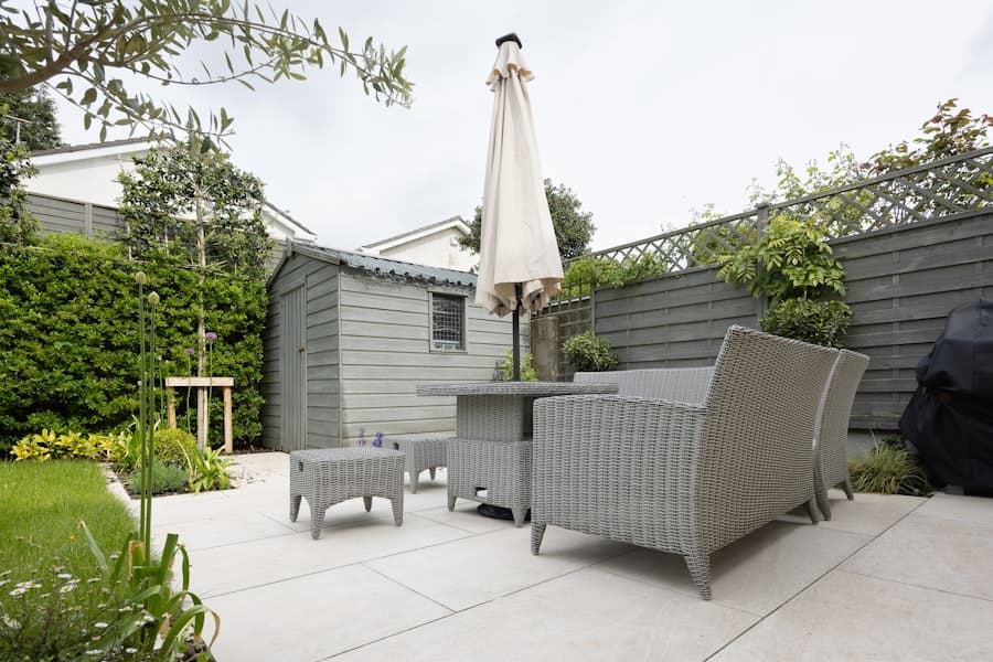 Backyard concrete patio with outdoor furniture and an umbrella
