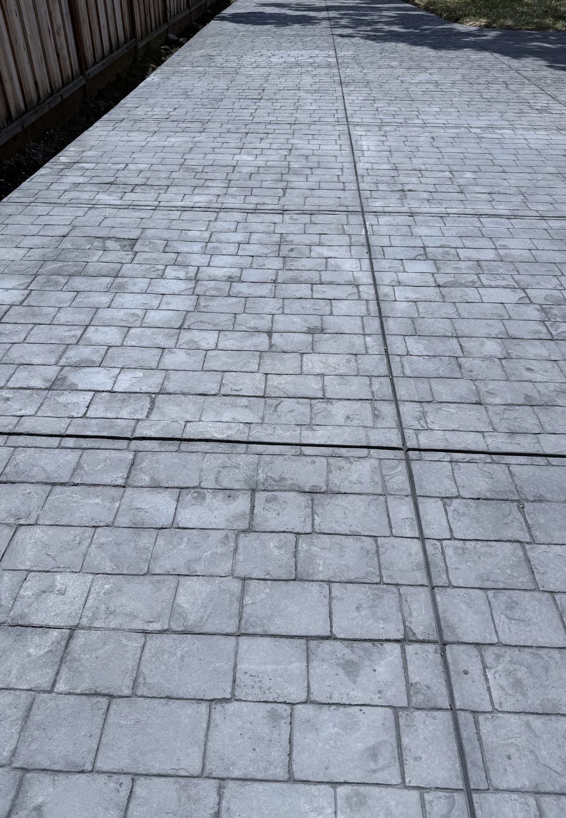 Finished stamped concrete driveway in a gray ashlar stone pattern
