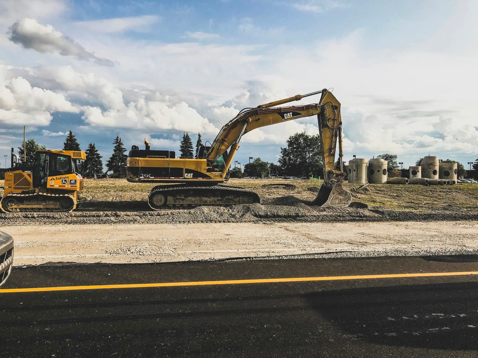 Excavator grading and preparing the sub-base ahead of a pour