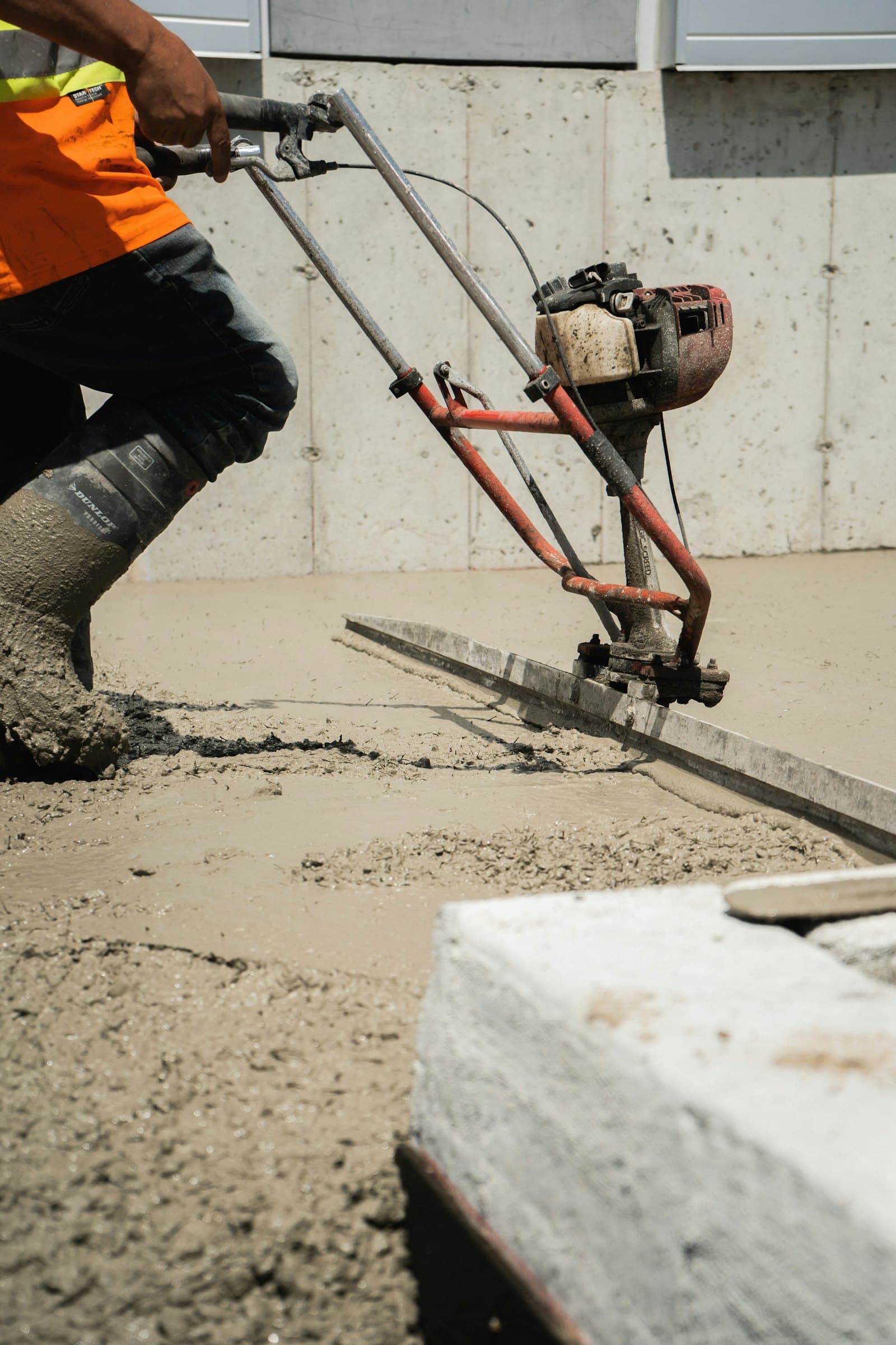 Concrete being placed and worked to grade on a new slab