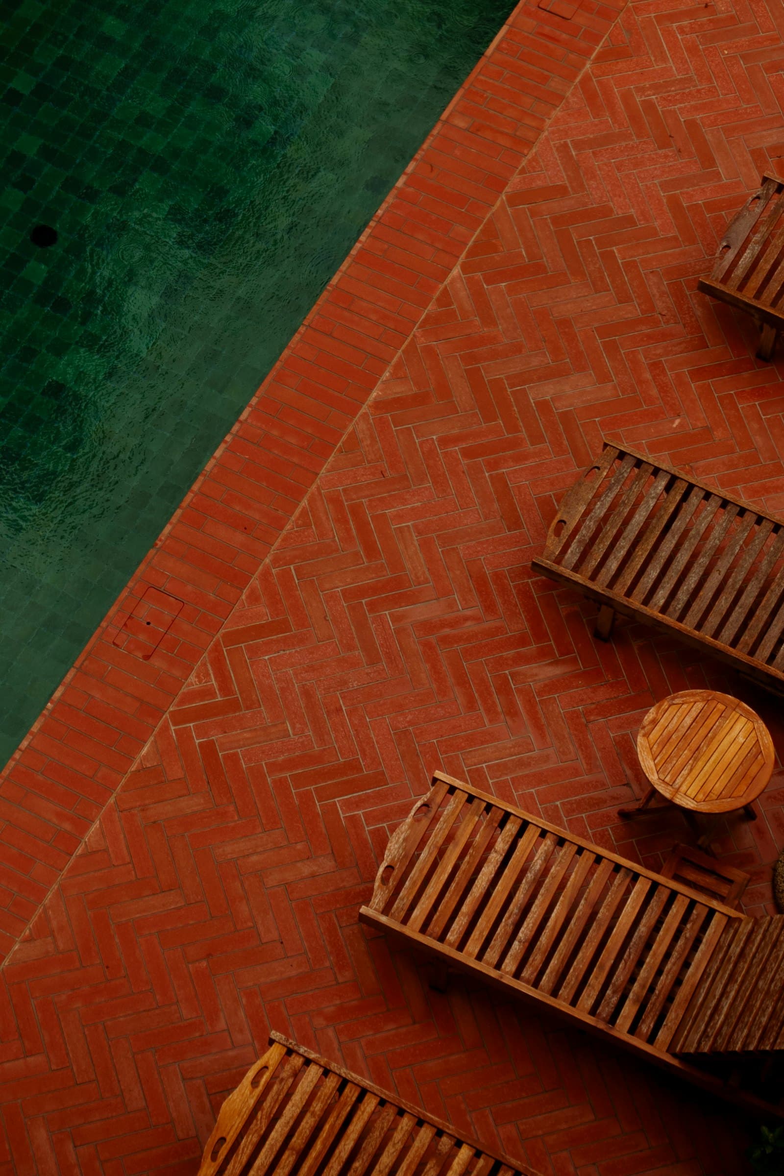 Concrete pool deck with seating alongside the water